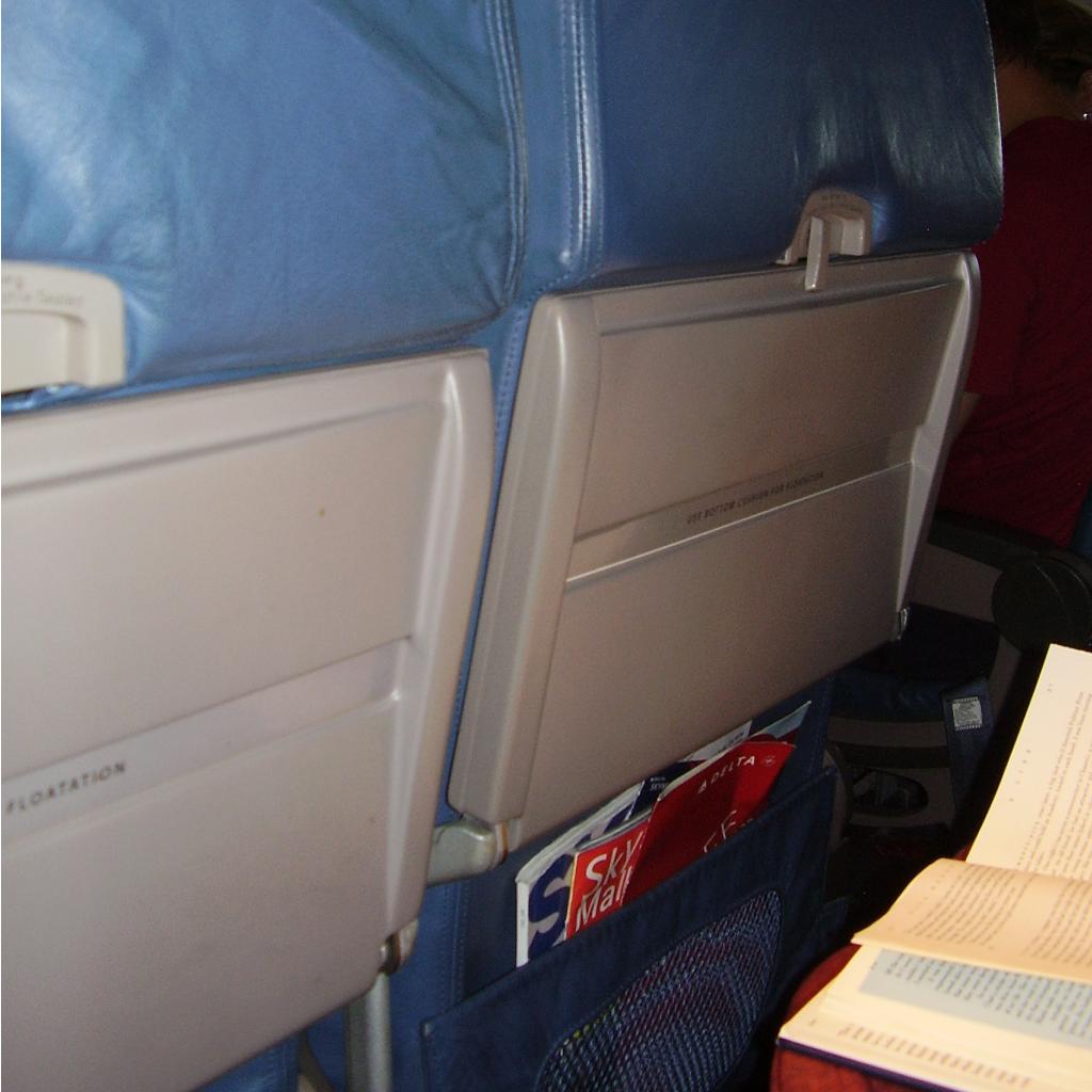 Seatback of a Delta airliner, including SkyMall Magazine