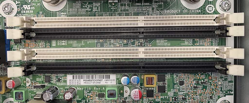 Close-up of four SDRAM DIMM memory slots on a computer motherboard.